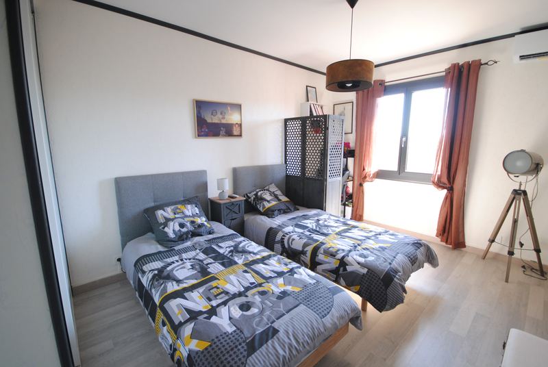 Chambre avec deux lits simples et télévision